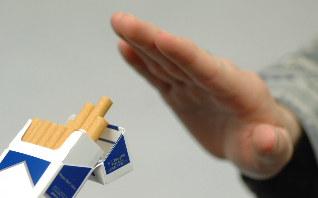 Hand refusing offered cigarettes